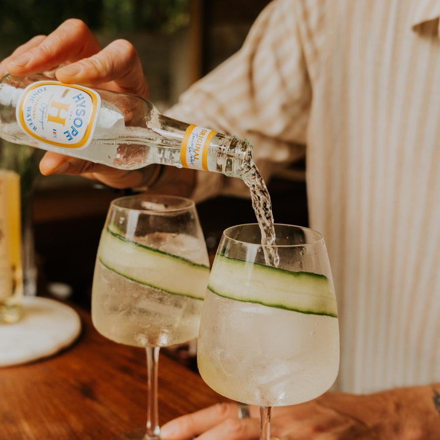 Préparation d'un Gin Tonic concombre avec le Tonic Water Original Hysope 75 cl, entouré d'ingrédients frais | MAISON COCKTAIL
