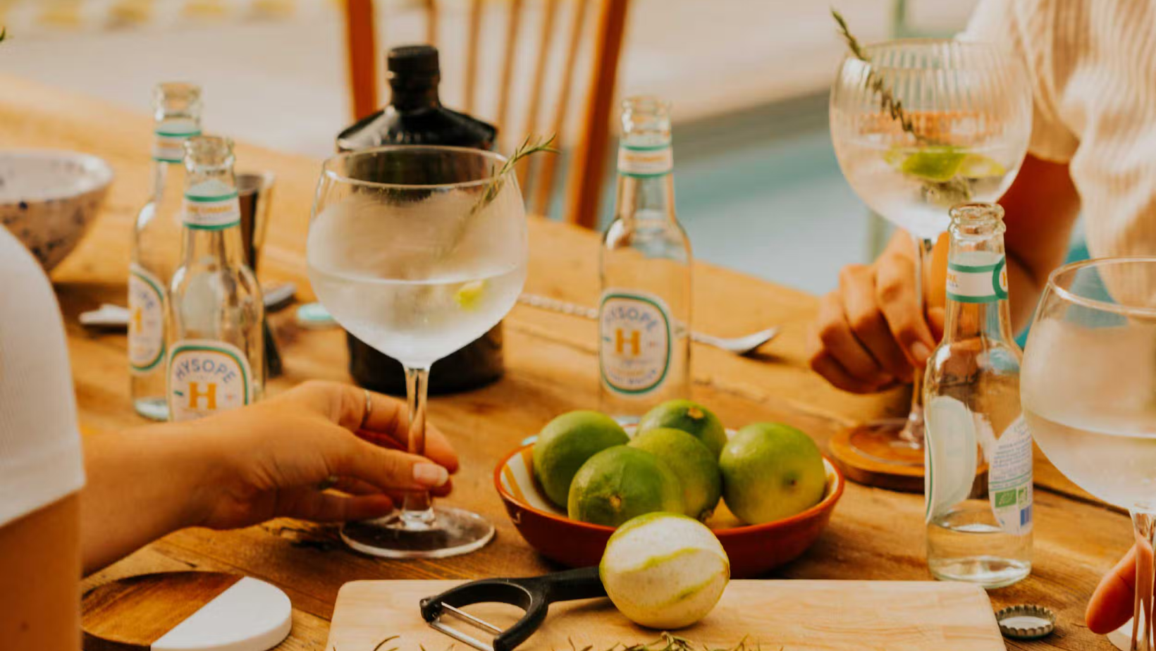 Un couple partage un moment au soleil avec des tonics HYSOPE bio, made in France et sans alcool, dans une ambiance conviviale et naturelle pour illustrer le Dry January | MAISON COCKTAIL